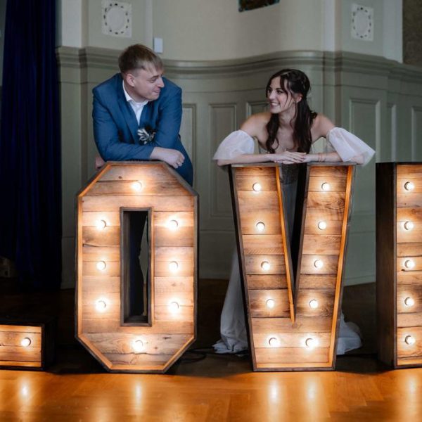 Love- Buchstaben aus Holz mit Brautpaar.
