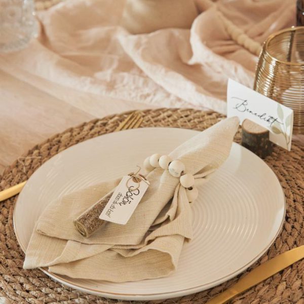 Tischdekoration zur Hochzeit mit goldenem Besteck und Gastgeschenk.